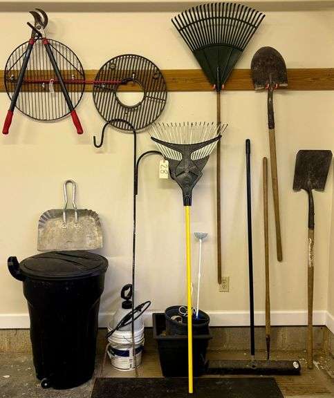 WALL LOT: 2 SHOVELS, HOE, PUSH BROOM, 2 RAKES, SPRAYER, RUBBERMAID GARBAGE CAN, 2 GRILL GRATES, CRAFTSMAN PRUNER, SHEPHERDS HOOK, METAL DUST PAN image