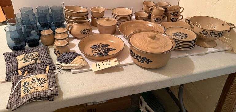 PFALTZGRAFF STONEWARE FOLK ART DISHES: COFFEE MUGS, 2 QUART CASSEROLE, CHIP AND DIP, EIGHT SAUCERS, SEVEN DESSERT PLATES, ONE HEART SHAPED PLATE, ONE CALENDAR, ONE SHELL PIPE PLATE, CREAM AND SUGAR, NINE BLUE GLASSES, POTHOLDERS, TWO SALT AND TWO PEPPER SHAKERS AND BUTTER WARMING DISH image