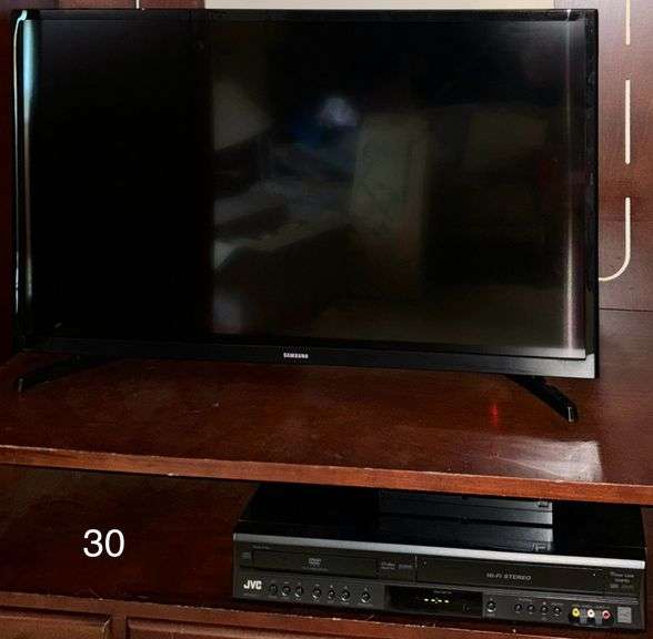 WOODEN FOUR-DOOR ENTERTAINMENT ARMOIRE APPROX. 62" HEIGHT X 42" WIDTH X 22" DEEP WITH CONTENTS TO INCLUDE 32 INCH SAMSUNG TELEVISION AND JVC VHS PLAYER (JVC SPEAKERS AND STEREO PLAYER NOT INCLUDED)