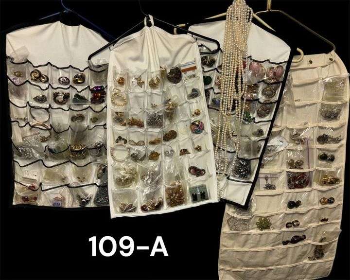 LARGE LOT OF COSTUME JEWELRY IN HANGING BAGS, BROOCHES, NECKLACES, EARRINGS, ETC. image
