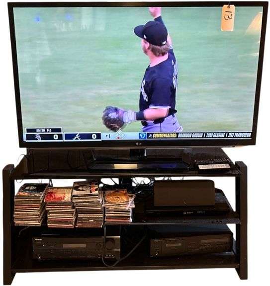 LG 55” TELEVISION ON TEMPERED GLASS TV STAND W/ CONTENTS TO INCLUDE ASSORTED CD’S, DVD’S, SONY BLU-RAY PLAYER, YAMAHA CASSETTE PLAYER, ETC. image