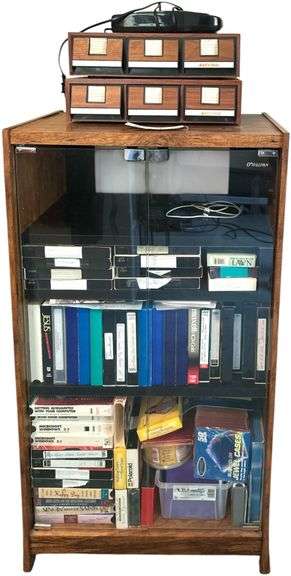 O’SULLIVAN STORAGE CABINET W/ 2 GLASS DOORS - CONTENTS TO INCLUDE ASSORTED VHS TAPES W/ VHS TAPE REWINDER image