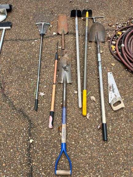 Trash Can with Rakes and Shovels image