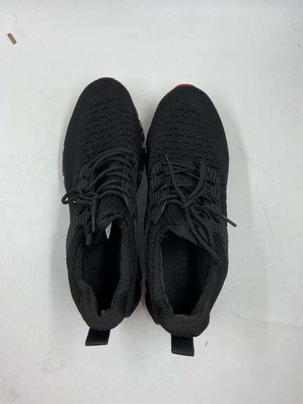 Black tennis shoes with red grippy bottom image