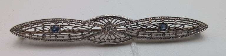 14 K white and yellow gold filigree style diamond and light blue sapphire brooch. image