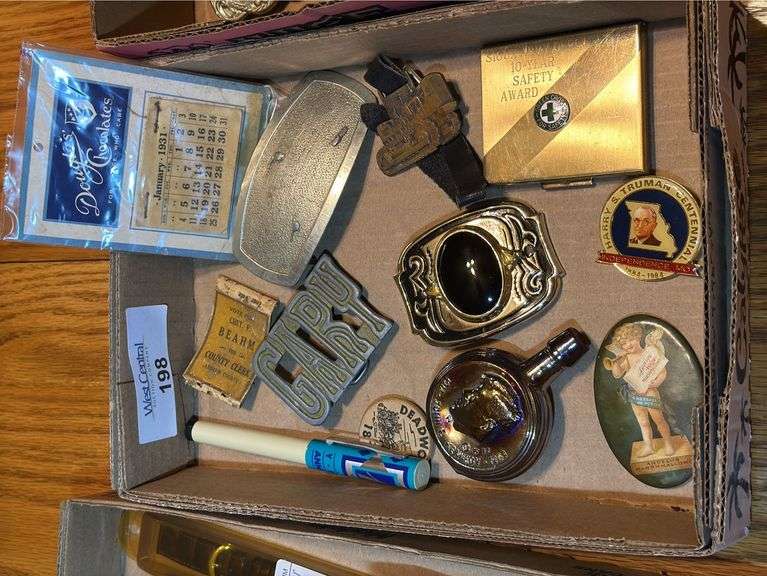 Collectibles Including Belt Buckles, JFK Liquor Bottle, and 1931 Calendar image