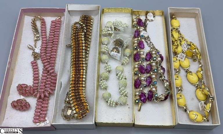 Costume jewelry sets, including Coro and Unmarked necklaces, bracelets, and earrings. Styles range from beaded necklaces with matching earrings to multi-strand bracelets. Materials appear to be gold-tone metal with colorful accents and embellishments image