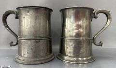 2 Pewter Tankards. Both Marked 'Quart' And Feature A Decorative Handle. One Mug Has GR 329 10 Stamped On It, And The Other Mug Has 1910 Stamped On It.