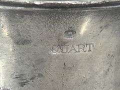 2 Pewter Tankards. Both Marked 'Quart' And Feature A Decorative Handle. One Mug Has GR 329 10 Stamped On It, And The Other Mug Has 1910 Stamped On It.