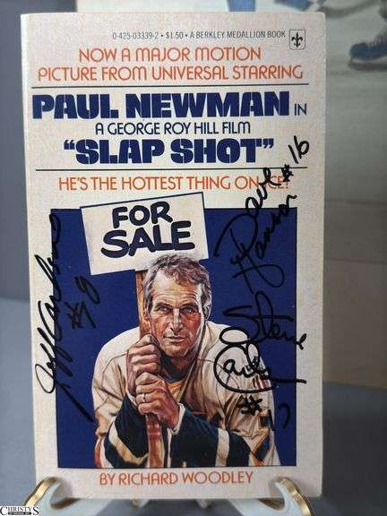 2 Mid-1970's Original Racers Hockey Photos Mounted on Cardboard and "Slap Shot" Memorabilia.  Includes a Hanson Brothers Autographed Photo, Autographed DVD Cover,  Sports Illustrated Slap Shot Autographed Magazine, "Slap Shot" The Book by Richard Woodley Autographed.