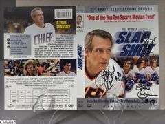 2 Mid-1970's Original Racers Hockey Photos Mounted on Cardboard and "Slap Shot" Memorabilia.  Includes a Hanson Brothers Autographed Photo, Autographed DVD Cover,  Sports Illustrated Slap Shot Autographed Magazine, "Slap Shot" The Book by Richard Woodley Autographed.