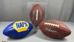 3 Footballs- One Blue NAPA Auto Parts and 2 Wilson National Football League.  One Wilson has autographed but they are fading and can not be read.  The other Wilson ball is in a display case.