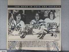 2 Mid-1970's Original Racers Hockey Photos Mounted on Cardboard and "Slap Shot" Memorabilia.  Includes a Hanson Brothers Autographed Photo, Autographed DVD Cover,  Sports Illustrated Slap Shot Autographed Magazine, "Slap Shot" The Book by Richard Woodley Autographed.