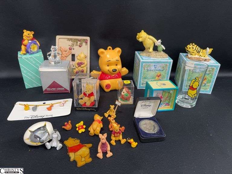 Misc. Winnie The Pooh Collectables Including a Bracelet, a Silver Deer Crystal Pooh, a Small Pooh Clock, Pooh Miniatures, Pooh Wind Up Music Box, 2 Royal Doulton Pooh Porcelain Figures in Boxes and More. image