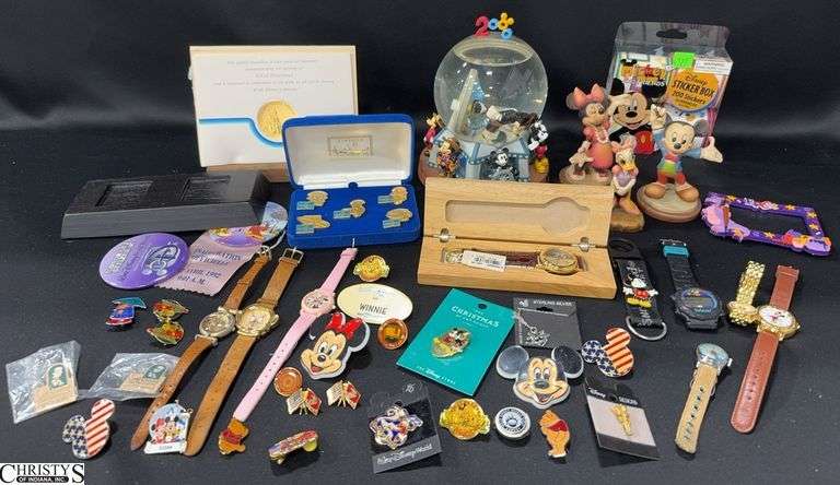 Disney / Mickey Mouse Watches, Buttons, Stickers, Pins, Sterling Silver Necklace, Classic Walt Disney Collector Pins, a Official Disneyana Convention Watch in Wooden Box, a Special Medallion Commemorating The Opening of Tokyo Disneyland, a Mickey Millennium Snow Globe, and 3 Limited Edition Anri Carved Wood Figures (Mickey, Minnie and Daisy).  The center piece inside the globe is out of place.  See Photo image