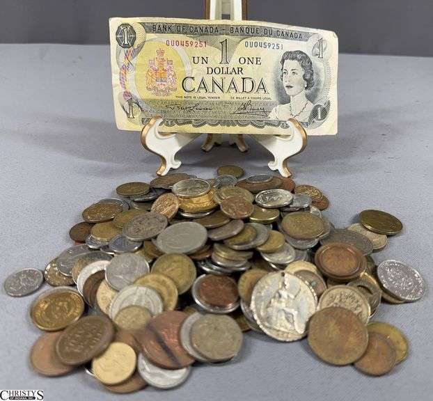 Foreign Coins and Currency.  Includes a Canadian One Dollar Bill,  10 Pence Coin, 1971 1 Deutsche Mark Coin, 1987 One Pound Coin, 1997 Twenty Pence Coin, 1965 20 Centavos Coin, 1963 10 Centime Coin, 1948 Two Shilling Coin and Many More.  A Few Tokens are also included. image