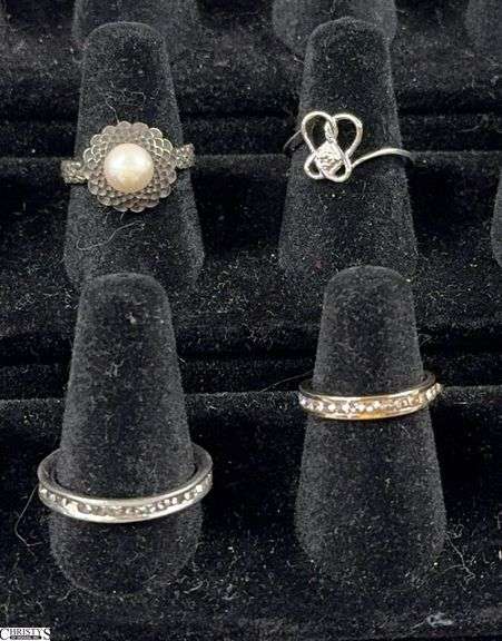 4 Rings.  3 are marked 925 and 1 is marked silver.  One of the band type rings is missing a single stone. image