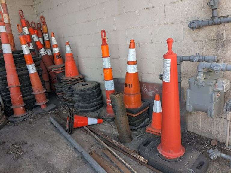Traffic control cones, signs, and roll of orange plastic barrier