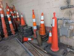 Traffic control cones, signs, and roll of orange plastic barrier