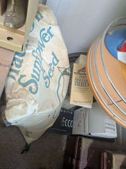 Hummingbird feeder, boxes of thistle seed, bag of sunlfower seed, bird guide image