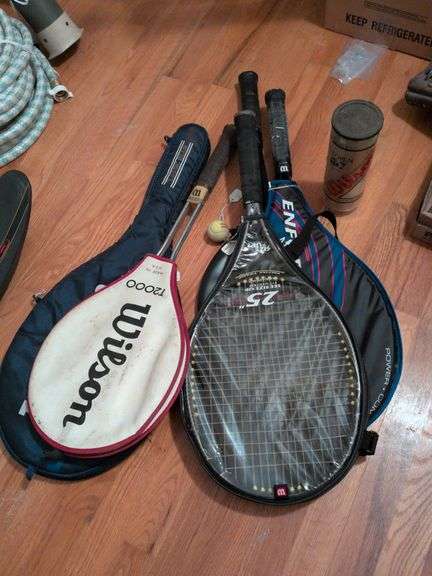 5 tennis rackets in cases with tennis balls image