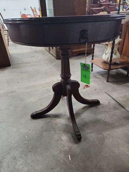 vintage Regency-style drum table with lion head pulls and reeded legs.