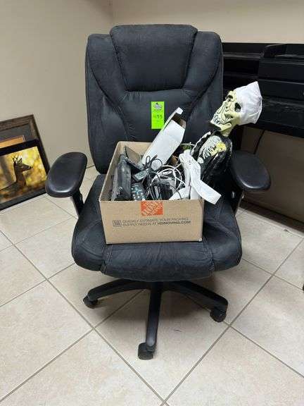 Black desk chair with box of office supplies ￼
