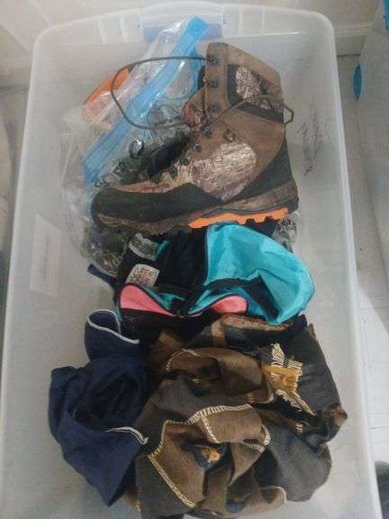 Plastic bin with size 11 camouflage boots. Ski bag and hunting bag. image