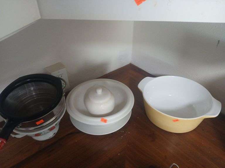 Kitchen supplies metal strainer and glass bowls. image