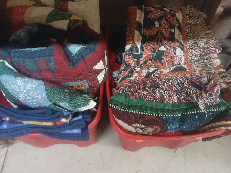 2 bins of holiday blankets and pillows. image