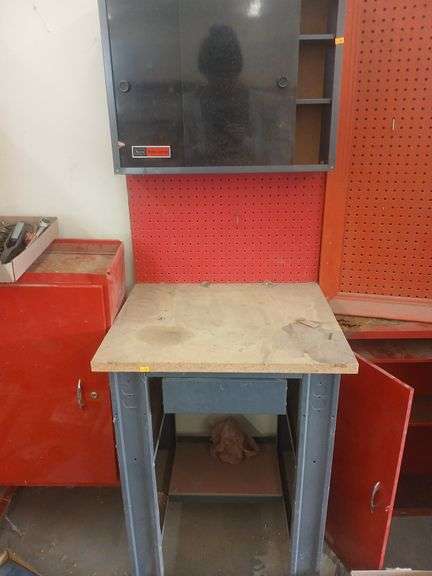 Metal cabinet with sliding doors and peg board. image