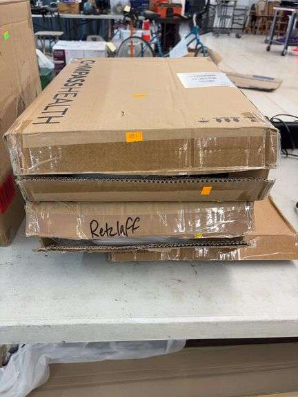 Two boxes of raised toilet seats and one standard toilet seat image