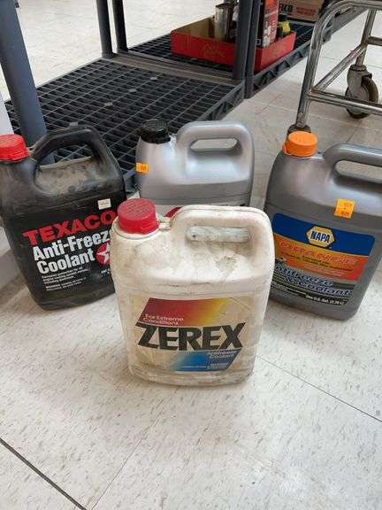Two partial bottles, and two full bottles of various brands of antifreeze image