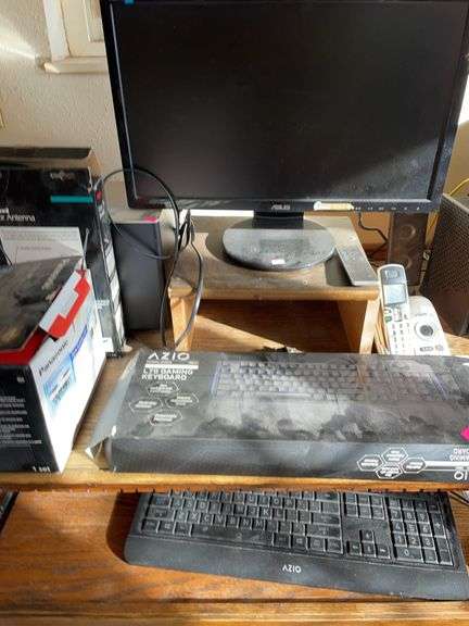 Contents of computer desk with computer monitor speakers and cordless phones. image