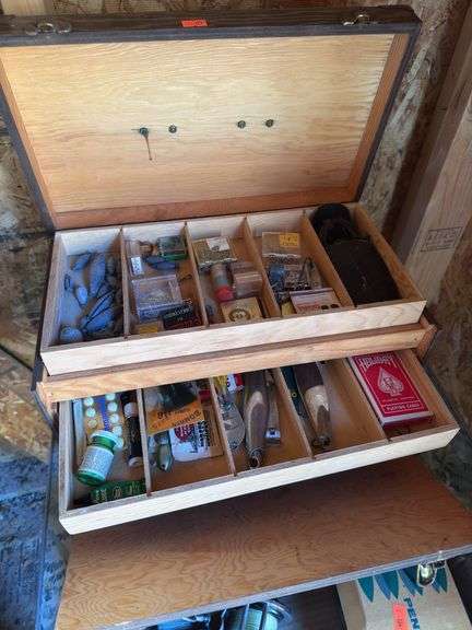 Wooden tackle box with fishing supplies inside. image
