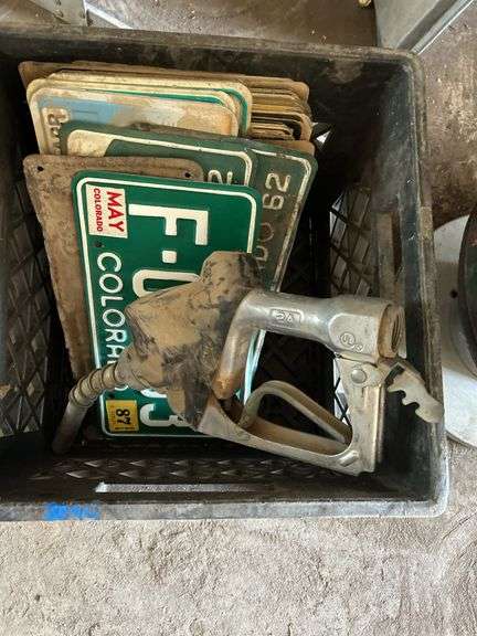 Crate of license plates, small Signs and gas pump handle