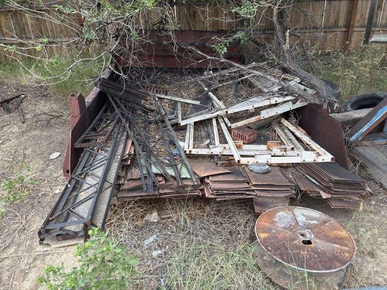 Dump truck bed with assortment of steel items in it.