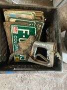 Crate of license plates, small Signs and gas pump handle