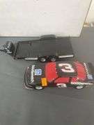 die-cast model of Dale Earnhardt's #3 Goodwrench NASCAR Lumina, which appears to be a 1:24 scale model, and it is depicted with a flatbed trailer.