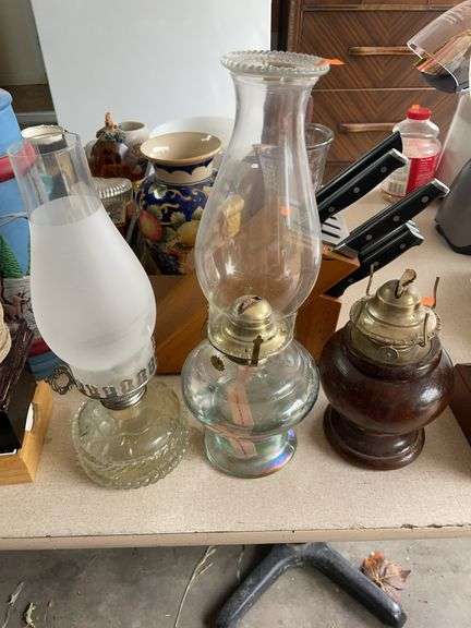 Two glass oil lamps, and one wooden one with no top image