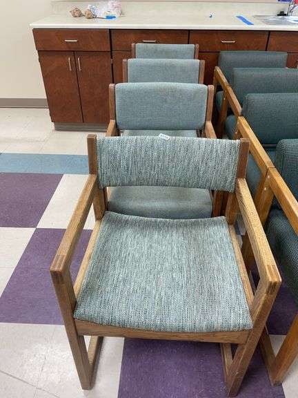 Lot of four wood and gray upholstered chairs. One is mismatched. image