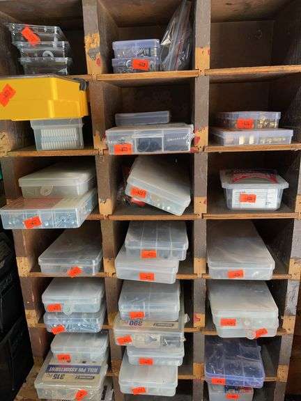 Row of plastic containers containing O-rings, small washers, nuts, and bolts and screws image