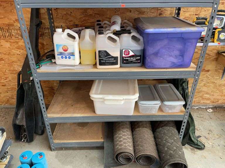 Contents of bottom, three shelves. Chemicals, buffing pads, and three rugs. image