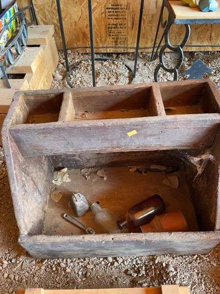Vintage wooden toolbox with miscellaneous bottles and a Bell image