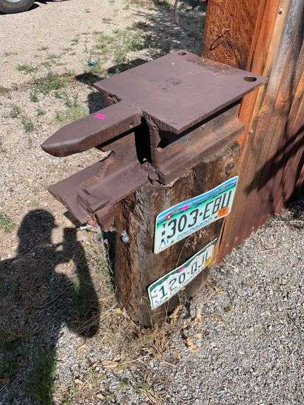 Antique pipe, wrench,  homemade anvil and three license plates image