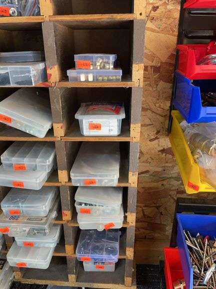 Row of plastic containers containing small screws, nuts, nuts, and bolts and brass compression inserts image