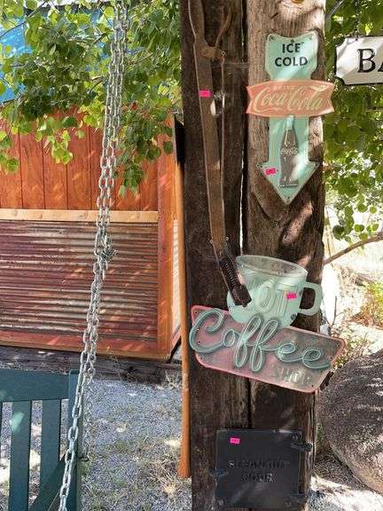 An ax, antique tool, stove door, and two signs image