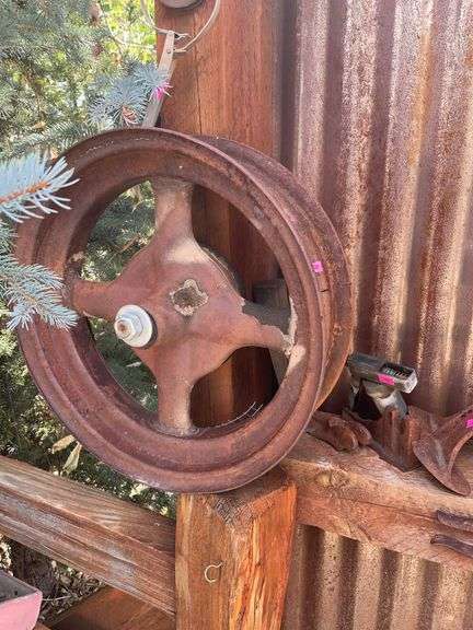 Two metal wheels and miscellaneous antique tools and shell casing image