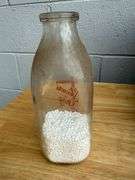 Collection of Glass Milk Bottles with Wooden Crate