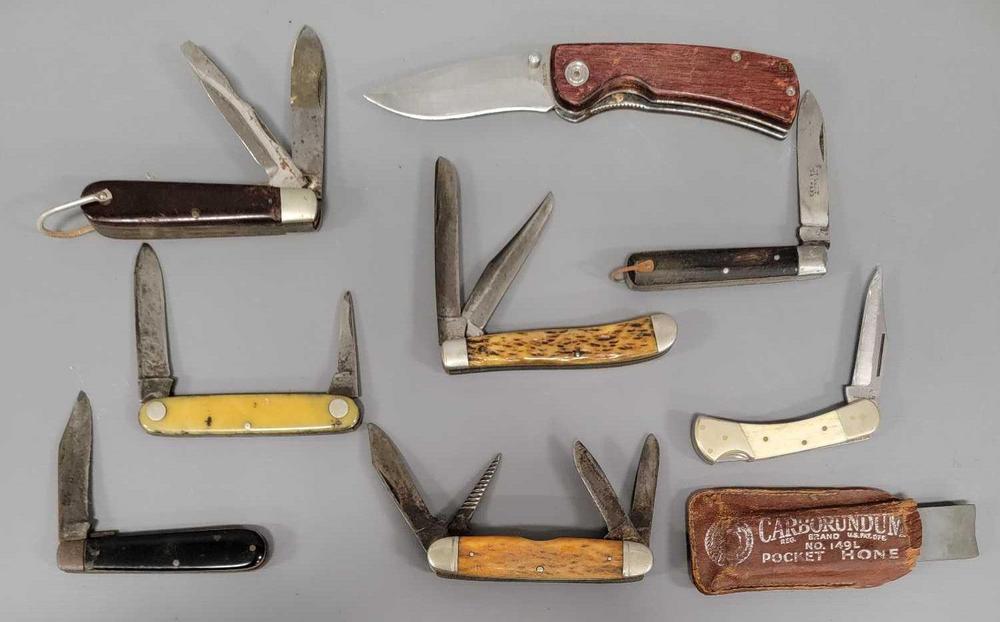 Group of eight old pocket knives and a pocket honing stone